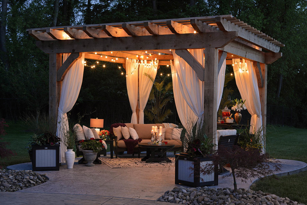 Inspiration for a transitional backyard concrete patio remodel in Other with a pergola