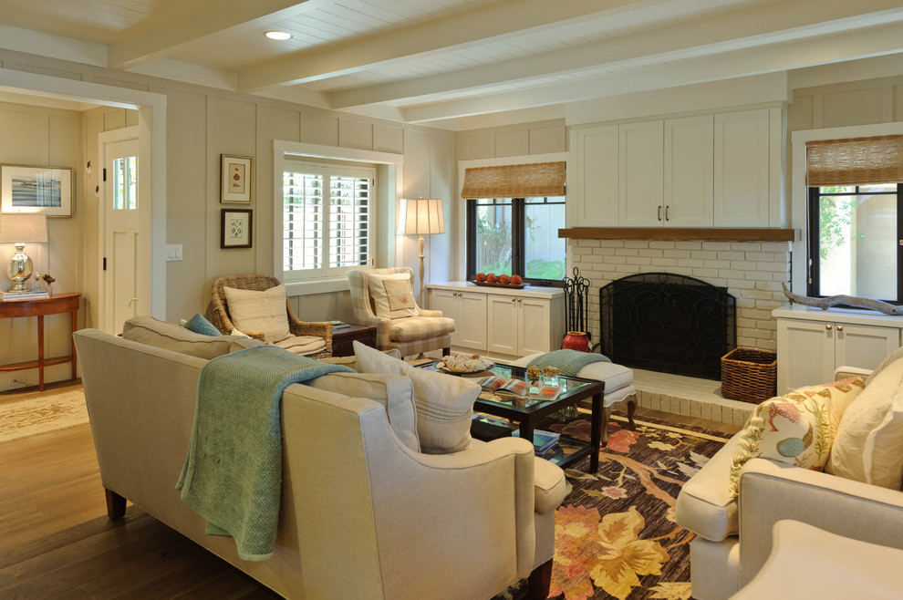 Large beach style open concept family room in Other with beige walls, medium hardwood floors, a standard fireplace, a brick fireplace surround, a concealed tv and brown floor.