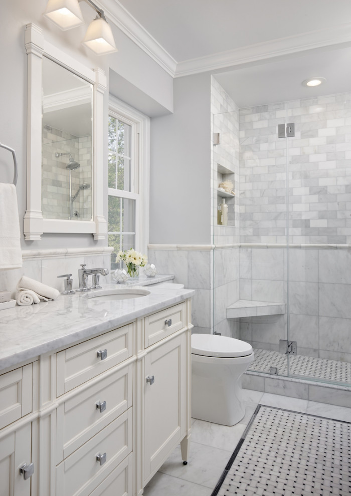 Mid-sized traditional master bathroom in DC Metro with furniture-like cabinets, white cabinets, an alcove shower, a two-piece toilet, gray tile, marble, grey walls, marble floors, an undermount sink, marble benchtops, grey floor, a hinged shower door and grey benchtops.