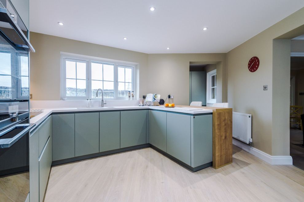 Esempio di una cucina ad U contemporanea di medie dimensioni con lavello da incasso, ante blu e pavimento in gres porcellanato