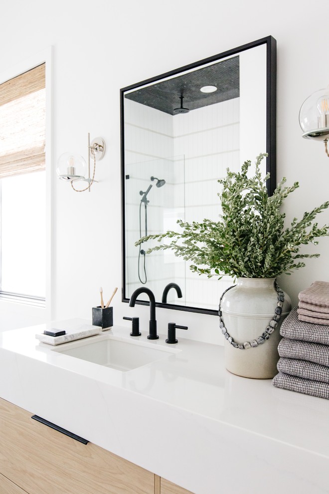 Design ideas for a mid-sized scandinavian master bathroom in Phoenix with flat-panel cabinets, light wood cabinets, a freestanding tub, an alcove shower, white walls, ceramic floors, an undermount sink, quartzite benchtops, black floor, a hinged shower door and white benchtops.