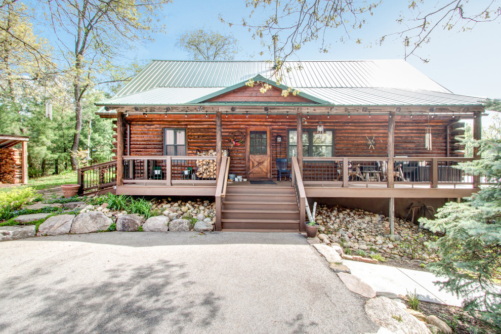 Huge mountain style backyard deck photo in Milwaukee with a roof extension