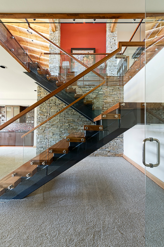 Large contemporary wood u-shaped staircase in Vancouver with open risers and glass railing.