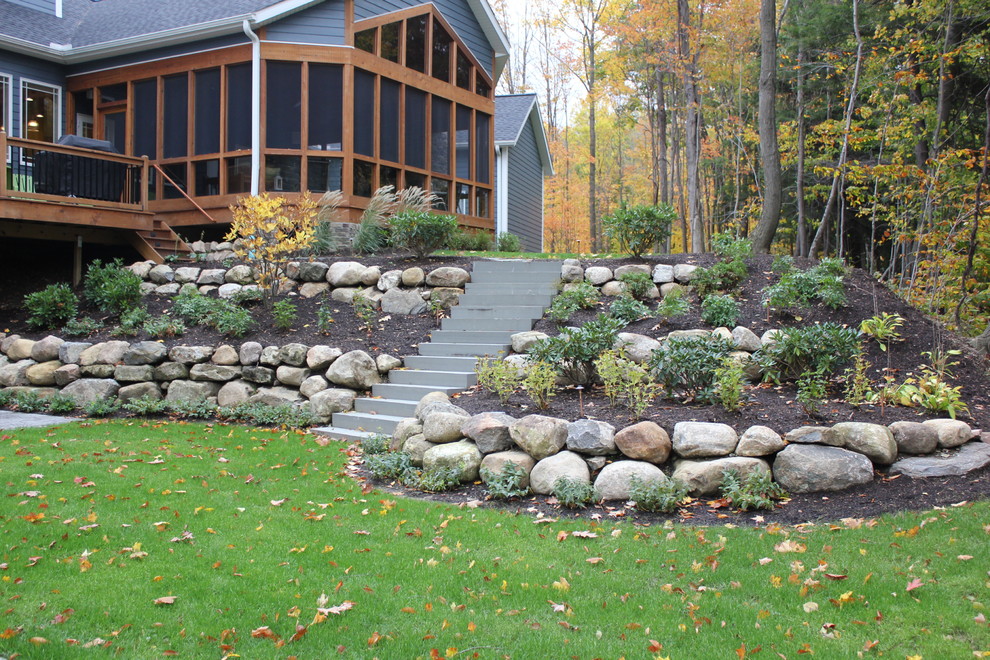 Inspiration for an arts and crafts backyard partial sun garden for fall in Other with a retaining wall and mulch.