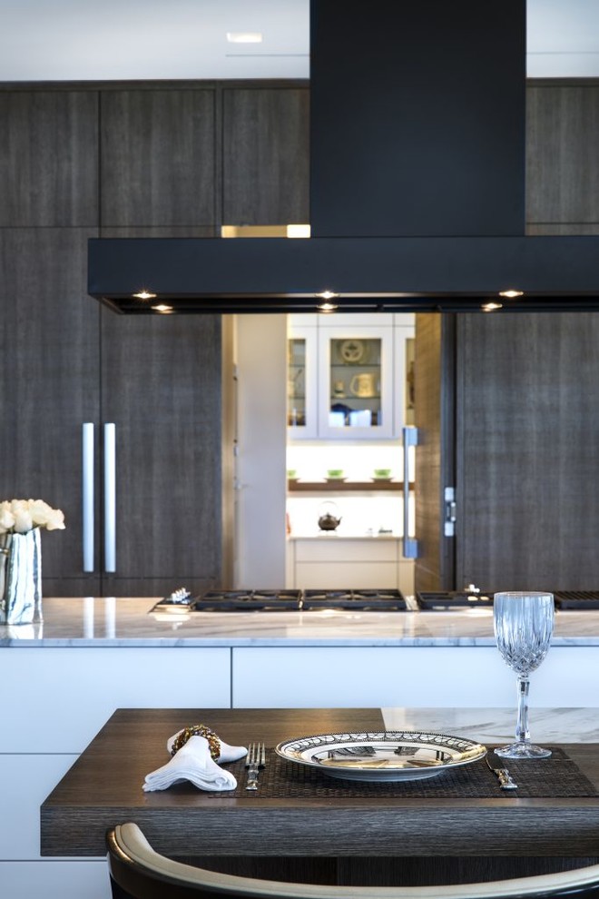 This is an example of a large modern single-wall open plan kitchen in Miami with flat-panel cabinets, dark wood cabinets, quartz benchtops, stainless steel appliances, with island, medium hardwood floors and brown floor.