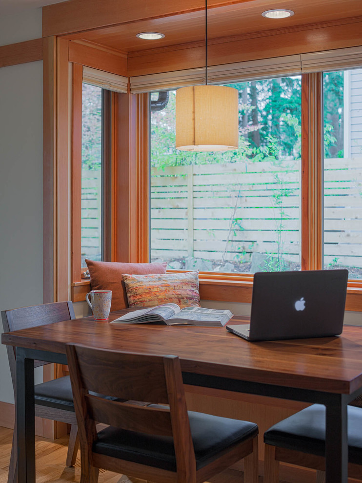 Mid-sized transitional l-shaped light wood floor open concept kitchen photo in Seattle with an undermount sink, flat-panel cabinets, medium tone wood cabinets, quartzite countertops, blue backsplash, glass tile backsplash, stainless steel appliances and an island