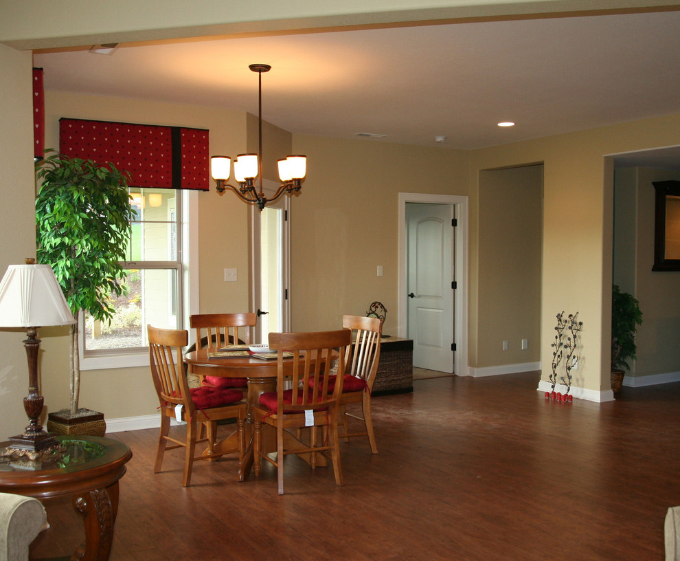 This is an example of a large traditional open plan dining in Milwaukee with beige walls, dark hardwood floors, a standard fireplace and a stone fireplace surround.