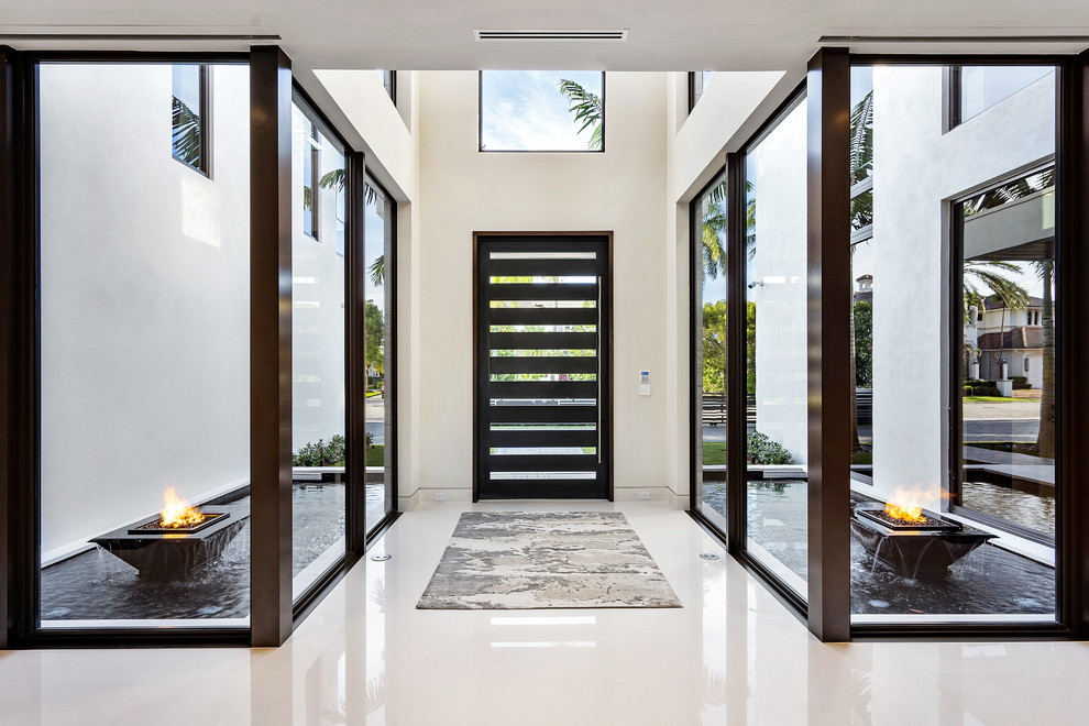 Inspiration for a large modern foyer in Miami with white walls, marble floors, a pivot front door, a glass front door and white floor.