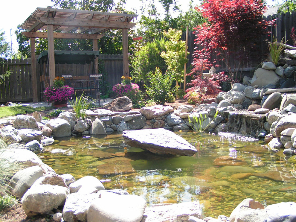 Photo of a large traditional backyard full sun garden in San Francisco with with pond and natural stone pavers.