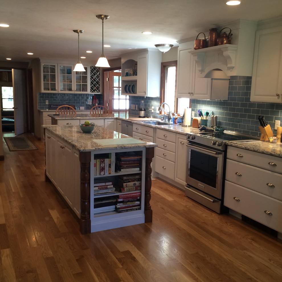 Eat-in kitchen - transitional u-shaped medium tone wood floor eat-in kitchen idea in Boston with an undermount sink, raised-panel cabinets, white cabinets, granite countertops, blue backsplash, glass tile backsplash, stainless steel appliances and an island