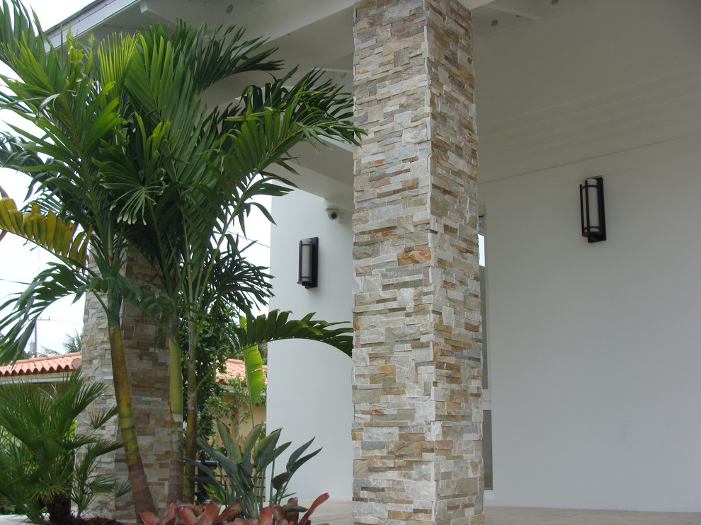 Diseño de fachada de casa beige contemporánea con revestimiento de piedra