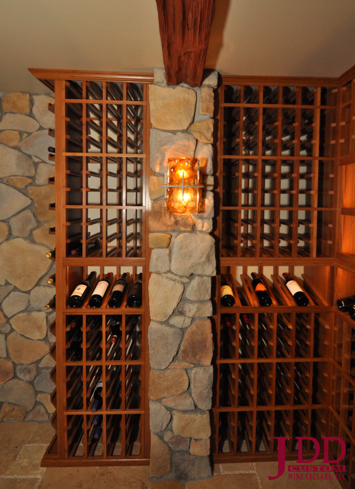 Large rustic wine cellar in San Diego with travertine flooring and storage racks.