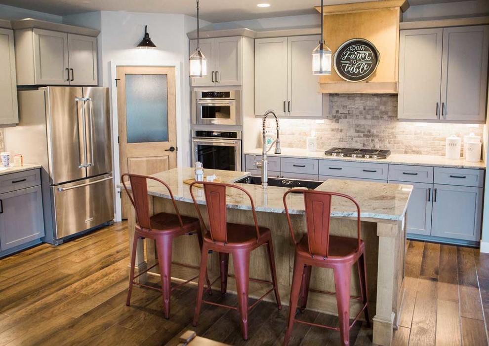 Kitchen - mid-sized transitional kitchen idea with a farmhouse sink, granite countertops, gray backsplash, stainless steel appliances and an island