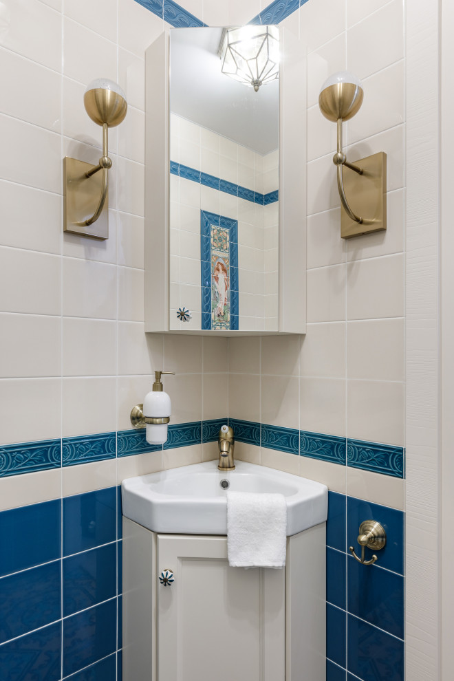 На фото: маленький туалет: освещение в классическом стиле с фасадами с утопленной филенкой, бежевыми фасадами, биде, синей плиткой, керамической плиткой, бежевыми стенами, полом из керамогранита, накладной раковиной, разноцветным полом, белой столешницей и встроенной тумбой для на участке и в саду