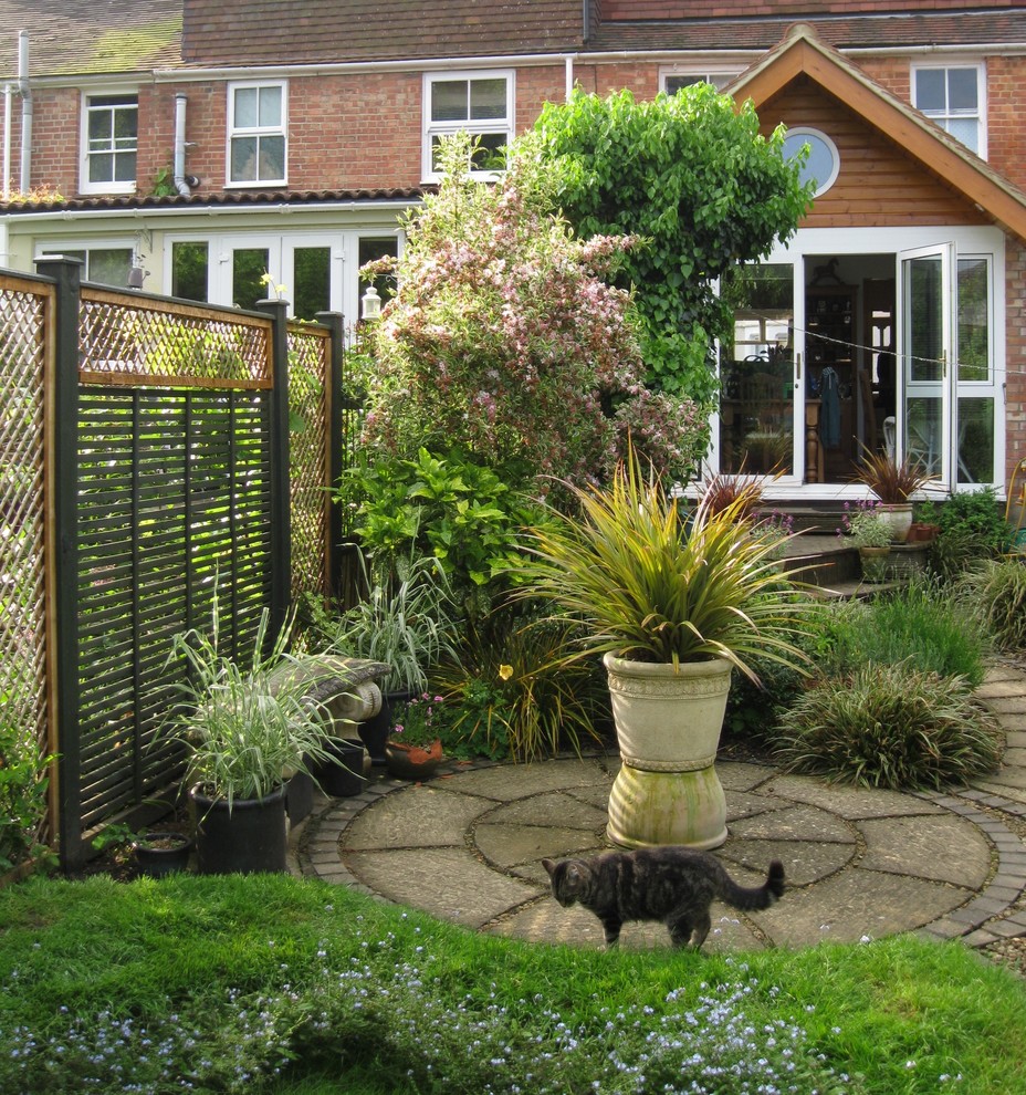 Photo of a mid-sized transitional backyard partial sun formal garden for fall in Oxfordshire with a vertical garden and concrete pavers.