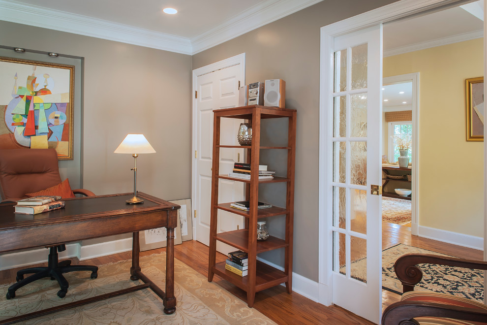 Mid-sized traditional study room in Other with brown walls, medium hardwood floors, a freestanding desk and no fireplace.