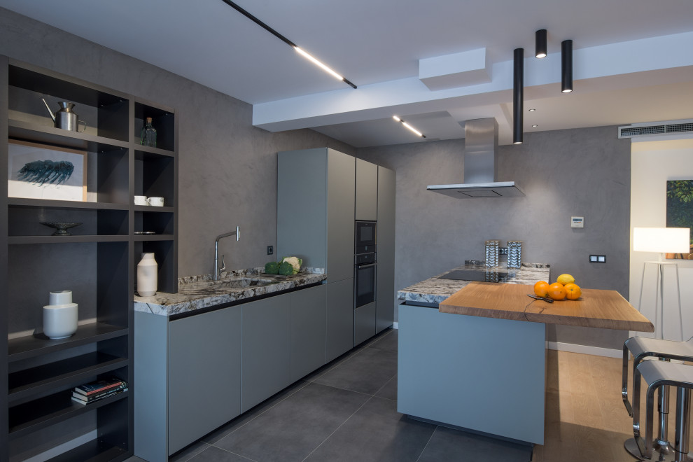 Example of a mid-sized minimalist open concept kitchen design in Madrid with an integrated sink, gray cabinets, granite countertops, black appliances, an island and gray countertops