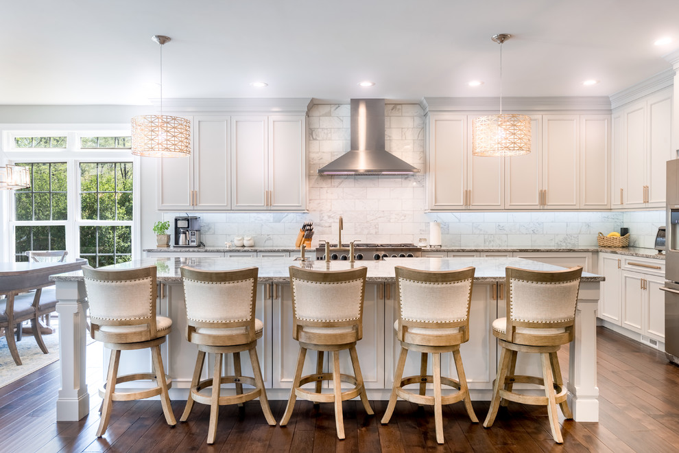 This is an example of a mid-sized traditional l-shaped eat-in kitchen in DC Metro with white cabinets, white splashback, stainless steel appliances, with island, grey benchtop, marble splashback, a farmhouse sink, beaded inset cabinets, granite benchtops, dark hardwood floors and brown floor.