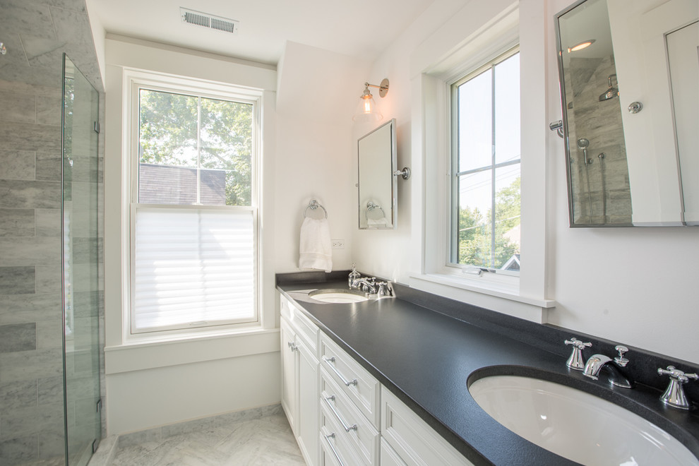 Inspiration for a mid-sized transitional master marble floor and gray floor alcove shower remodel in Chicago with recessed-panel cabinets, white cabinets, white walls, an undermount sink, solid surface countertops and a hinged shower door
