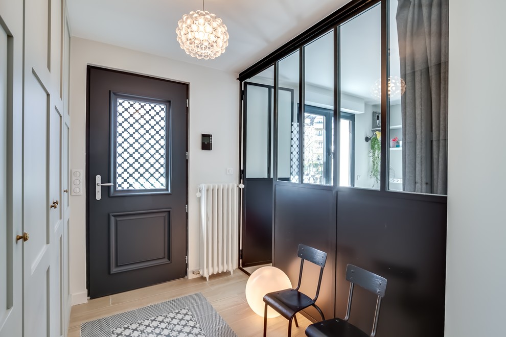 This is an example of a mid-sized contemporary vestibule in Paris with light hardwood floors.