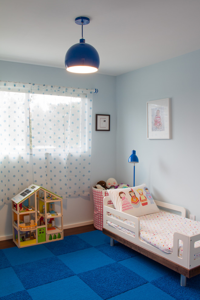 Small modern kids' room in Portland with blue walls and dark hardwood floors for girls.