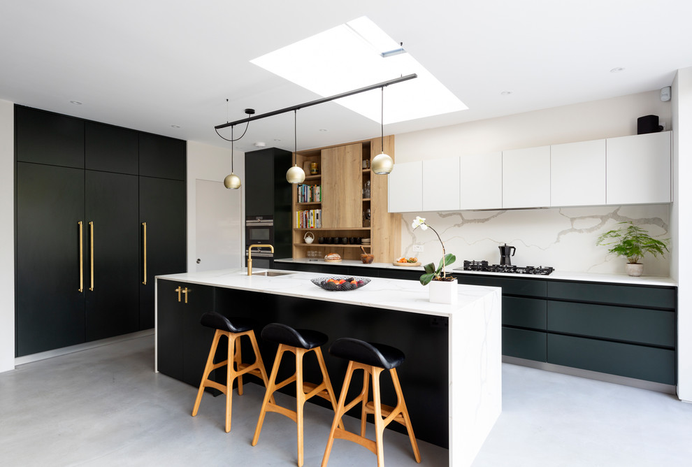 Inspiration for a mid-sized contemporary l-shaped open plan kitchen in London with an integrated sink, flat-panel cabinets, green cabinets, solid surface benchtops, white splashback, marble splashback, stainless steel appliances, porcelain floors, with island, grey floor and white benchtop.