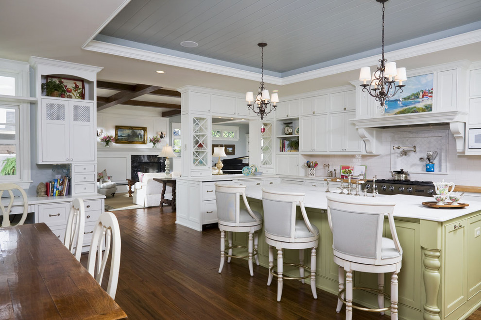 This is an example of a large traditional l-shaped eat-in kitchen in Minneapolis with shaker cabinets, white cabinets, white splashback, stainless steel appliances, dark hardwood floors, with island, marble benchtops and subway tile splashback.