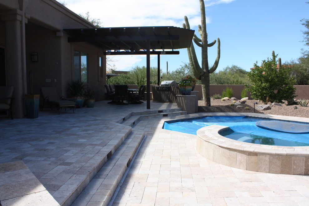 Mid-sized mediterranean backyard custom-shaped lap pool in Phoenix with a hot tub and tile.