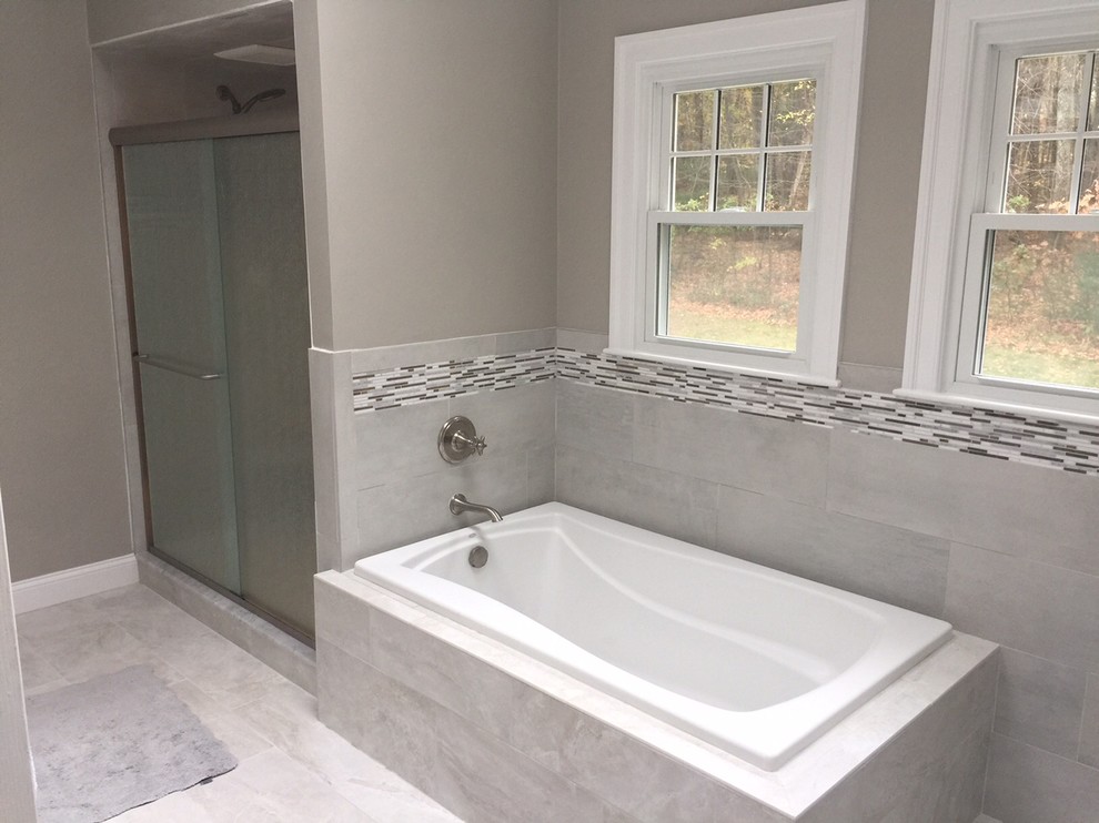 На фото: главная ванная комната в стиле модернизм с фасадами с выступающей филенкой, белыми фасадами, накладной ванной, душем в нише, серой плиткой, керамогранитной плиткой и столешницей из гранита с