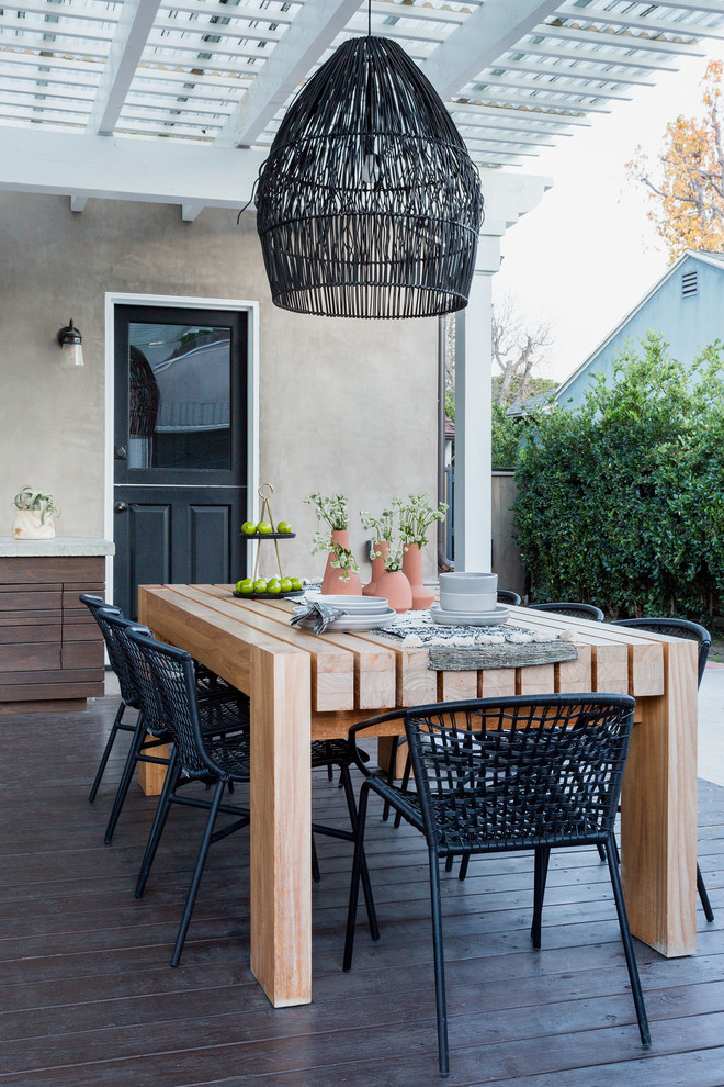 Example of a beach style deck design in Los Angeles with a pergola