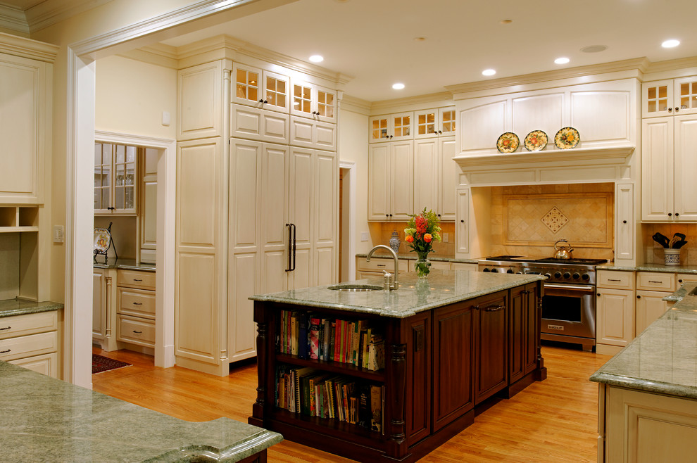 Photo of a traditional eat-in kitchen in DC Metro with flat-panel cabinets, white cabinets, beige splashback, stainless steel appliances, light hardwood floors and multiple islands.