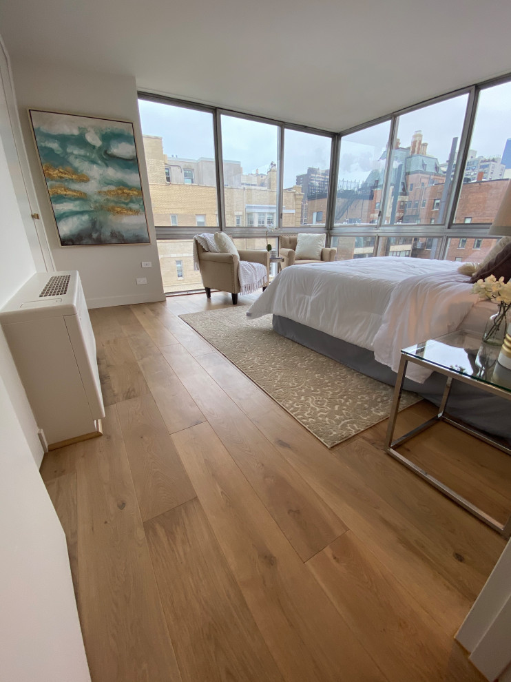 Ispirazione per una grande camera da letto minimalista con pareti bianche, pavimento in legno massello medio e pavimento marrone