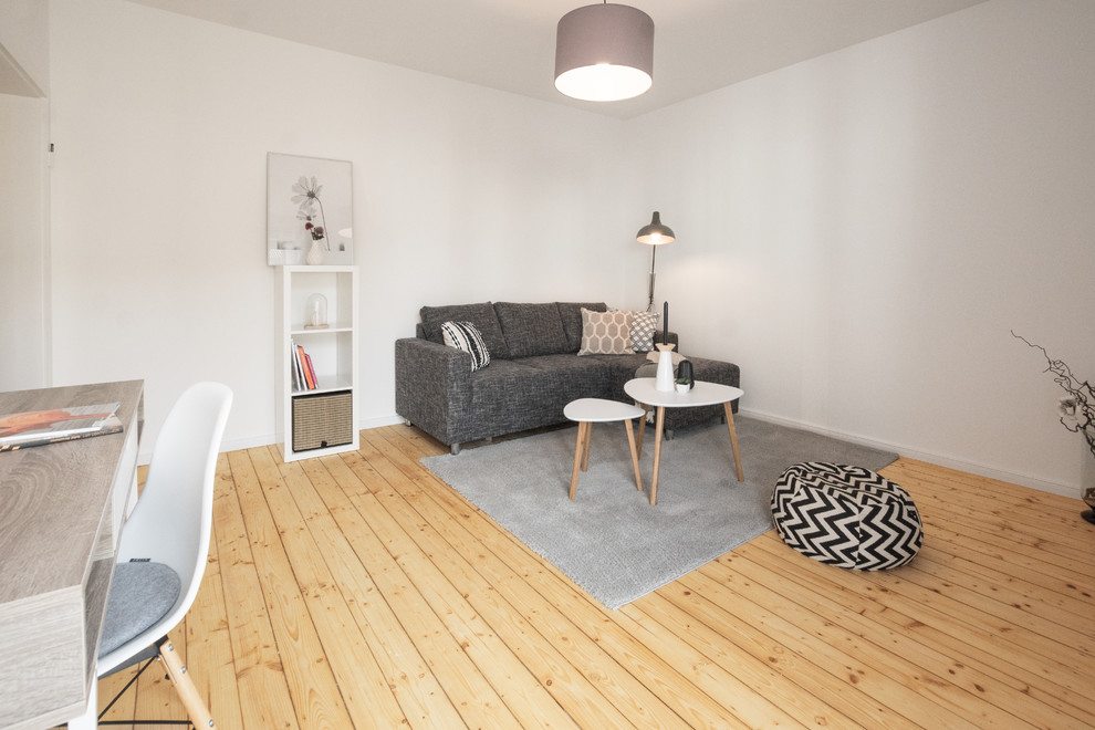 Kleines Nordisches Wohnzimmer mit hellem Holzboden in Köln