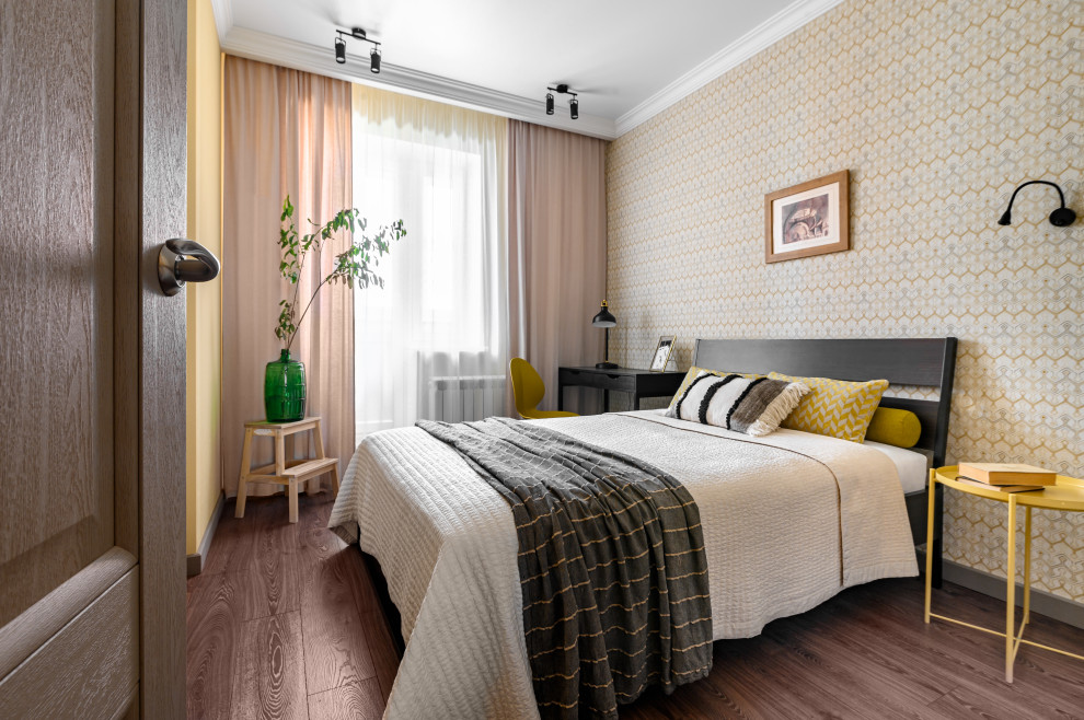 Small contemporary master and grey and white bedroom with beige walls, dark hardwood flooring, brown floors and wallpapered walls.