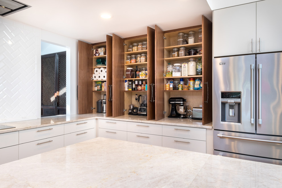 Photo of a large transitional l-shaped kitchen pantry in Portland with flat-panel cabinets, medium wood cabinets, quartzite benchtops, white splashback, ceramic splashback, stainless steel appliances and with island.