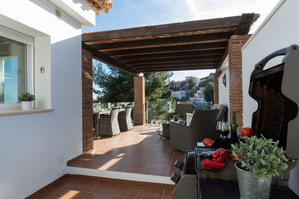Diseño de terraza in patio delantero With cocina exterior, suelo de baldosas and pérgola