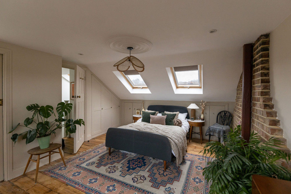 Ispirazione per una camera da letto chic con pareti beige, pavimento in legno massello medio, pavimento marrone e soffitto a volta