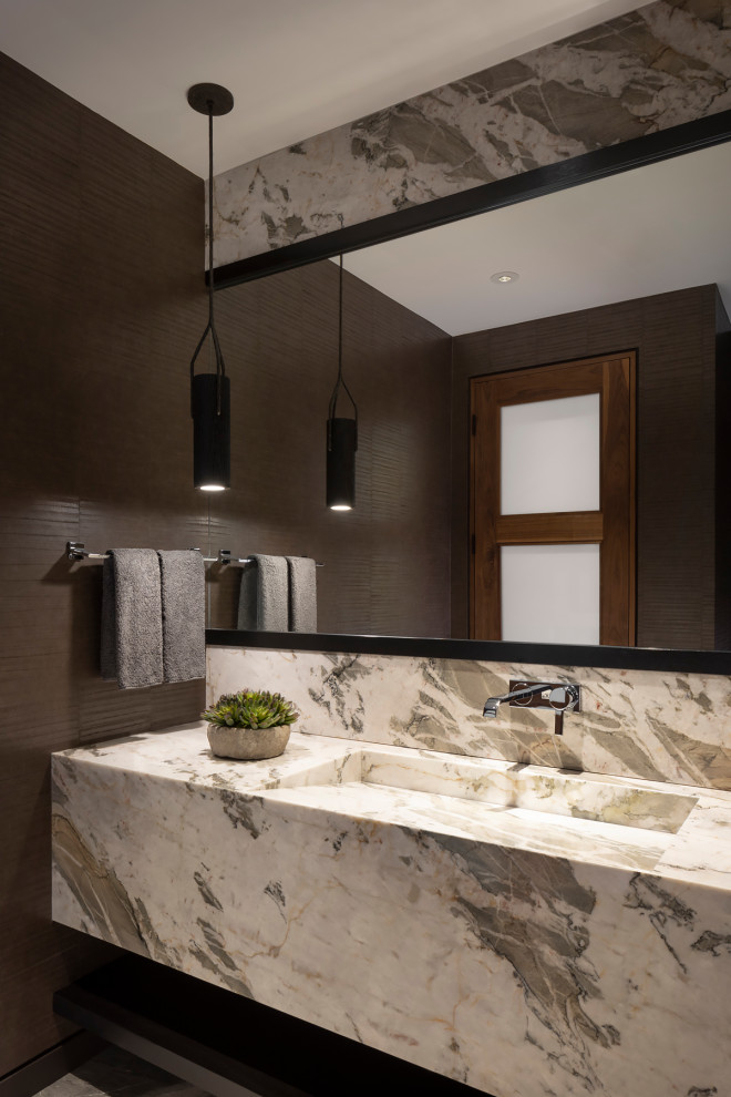 This is an example of a mid-sized modern powder room in Phoenix with brown tile, brown walls, a trough sink, quartzite benchtops and a floating vanity.