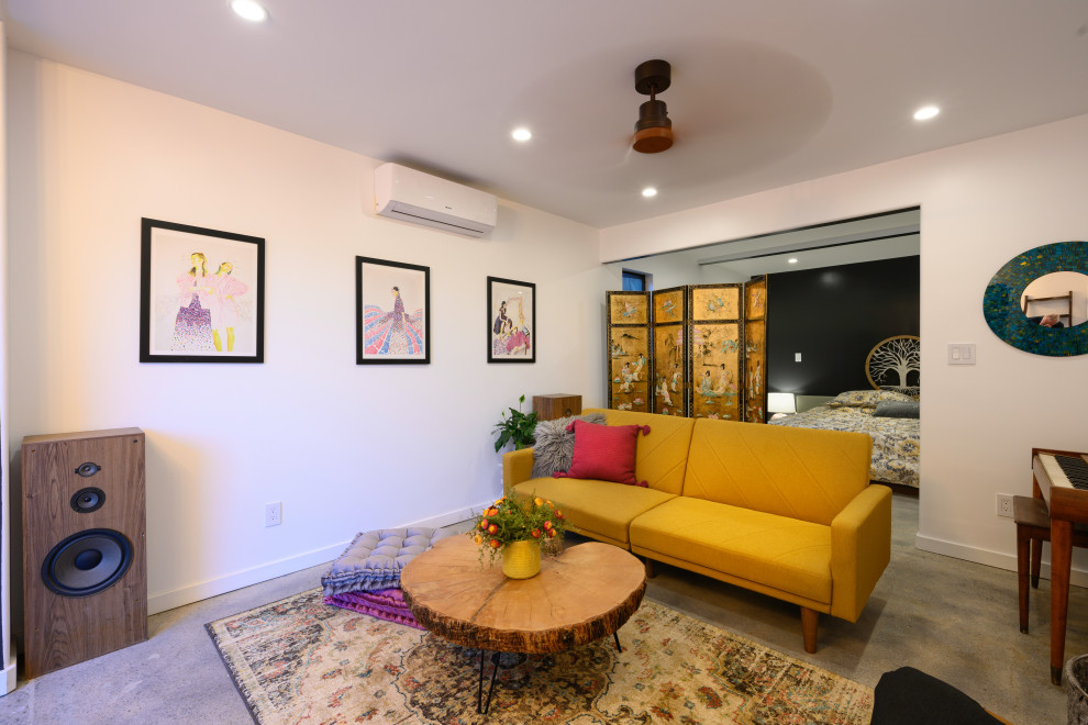 На фото: открытая гостиная комната среднего размера в стиле рустика с бежевыми стенами, серым полом и бетонным полом