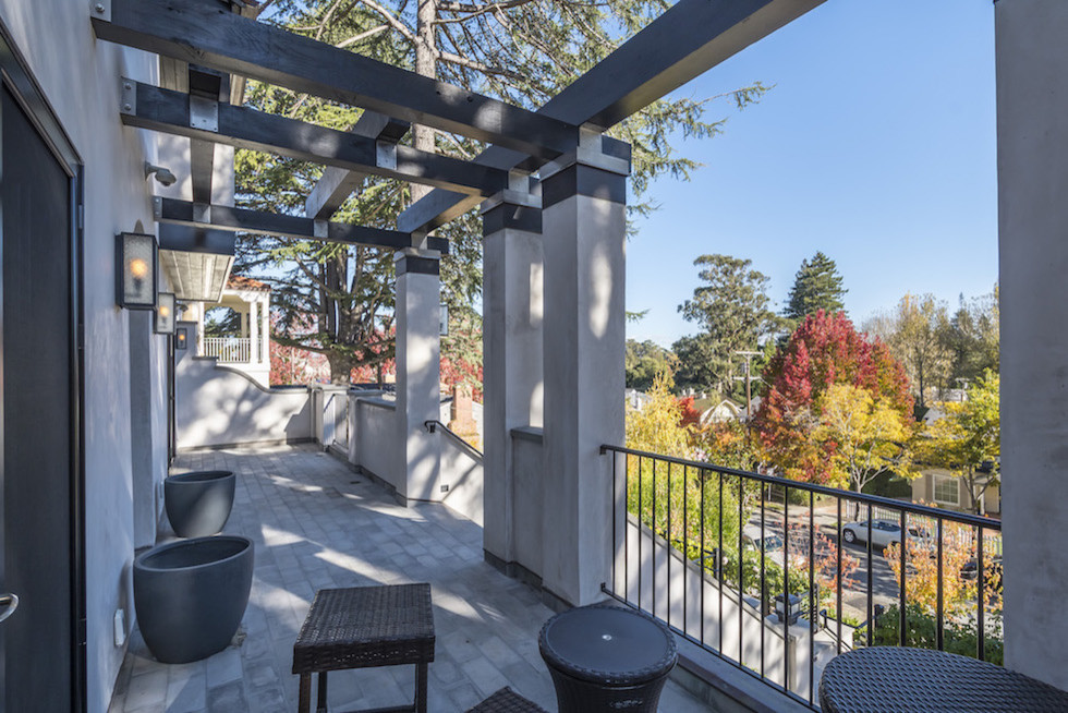 This is an example of a large contemporary front yard verandah in San Francisco with tile and a pergola.
