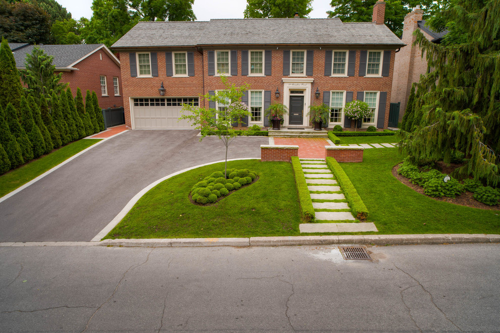 This is an example of a large contemporary front yard partial sun formal garden for summer in Toronto with a garden path and natural stone pavers.