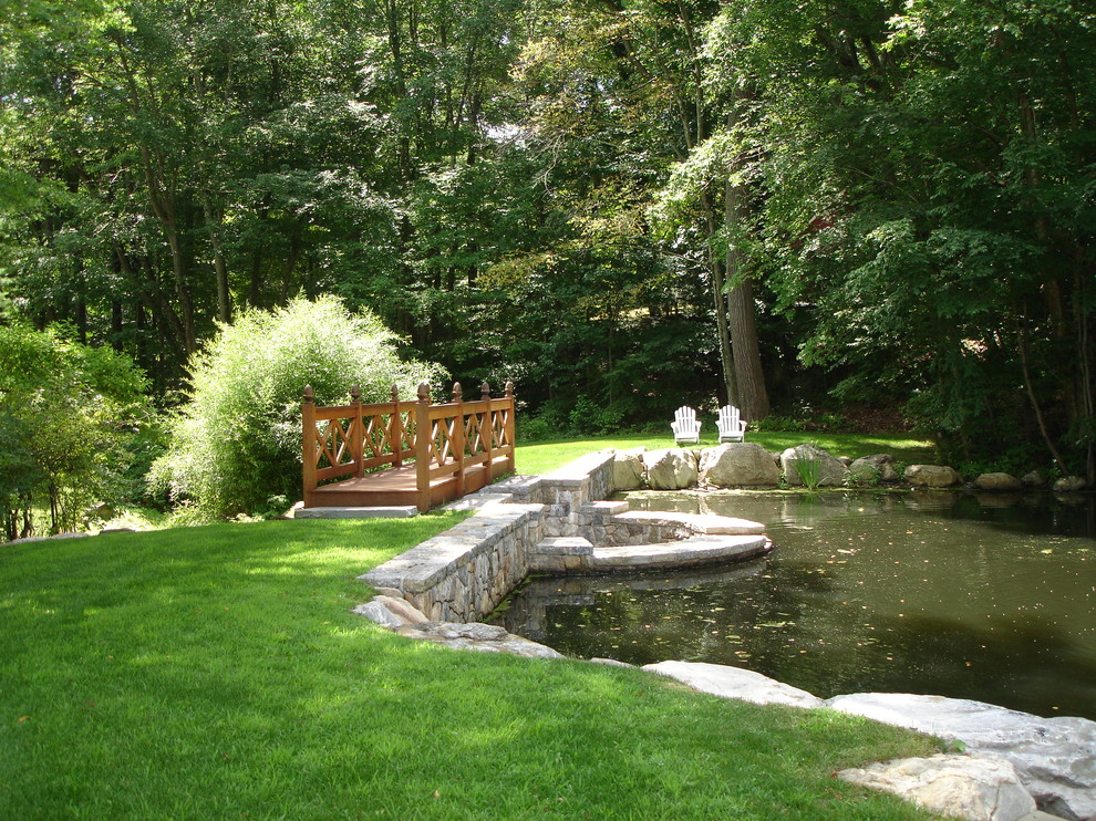 Expansive traditional backyard partial sun formal garden in New York with with pond and natural stone pavers for spring.
