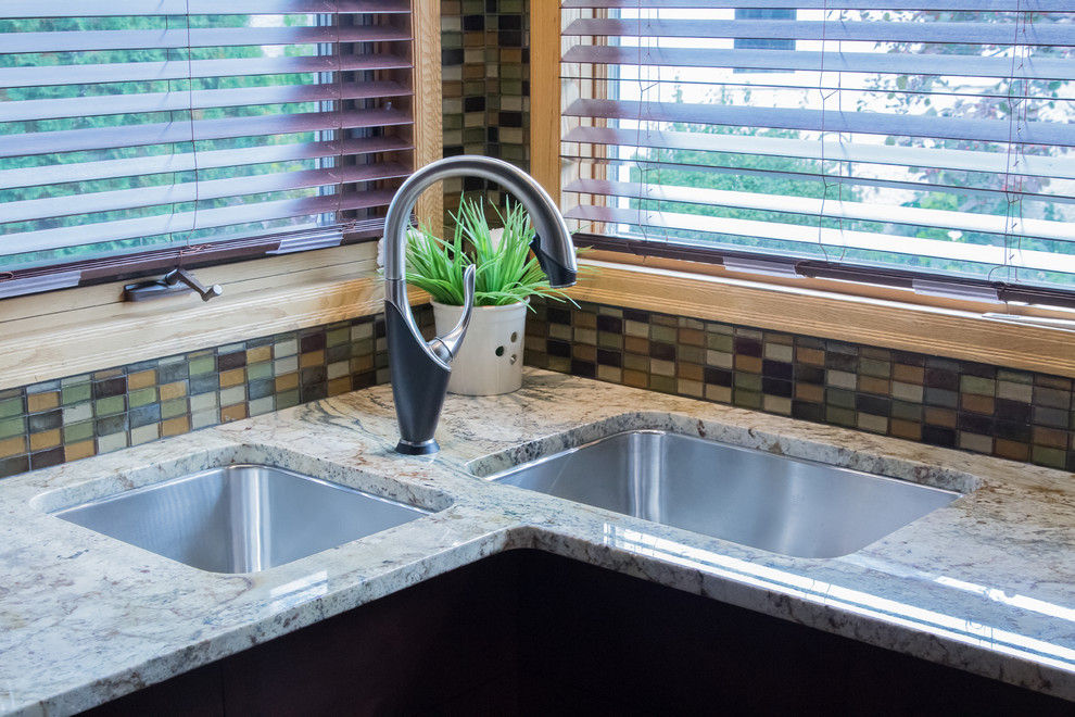 Inspiration for a contemporary ceramic tile kitchen remodel with a double-bowl sink, shaker cabinets, dark wood cabinets, granite countertops, multicolored backsplash, glass tile backsplash, paneled appliances and an island