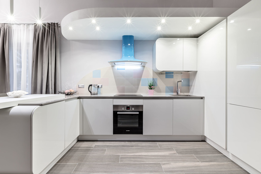 Inspiration for a large contemporary u-shaped open plan kitchen in Milan with an undermount sink, flat-panel cabinets, white cabinets, solid surface benchtops, multi-coloured splashback, ceramic splashback, stainless steel appliances, porcelain floors and a peninsula.