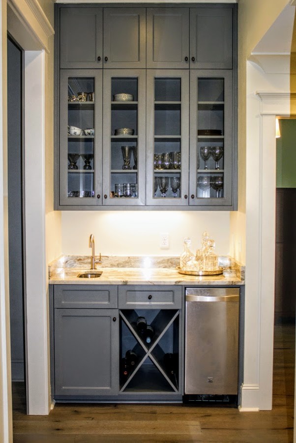 Design ideas for a small transitional single-wall wet bar in Atlanta with an undermount sink, glass-front cabinets, grey cabinets, granite benchtops, medium hardwood floors and brown floor.