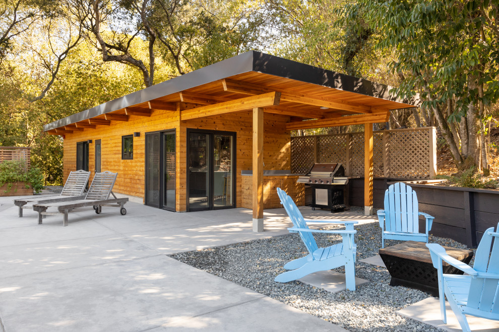 Small contemporary bungalow tiny house in San Francisco with wood cladding, a flat roof, a metal roof, shiplap cladding and a brown roof.