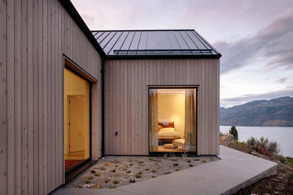 Exempel på ett mellanstort skandinaviskt grått hus, med allt i ett plan, sadeltak och tak i metall
