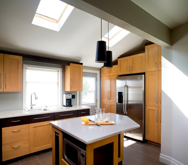 Open concept kitchen - transitional l-shaped porcelain tile open concept kitchen idea in Vancouver with a single-bowl sink, shaker cabinets, light wood cabinets, quartz countertops, stainless steel appliances and an island