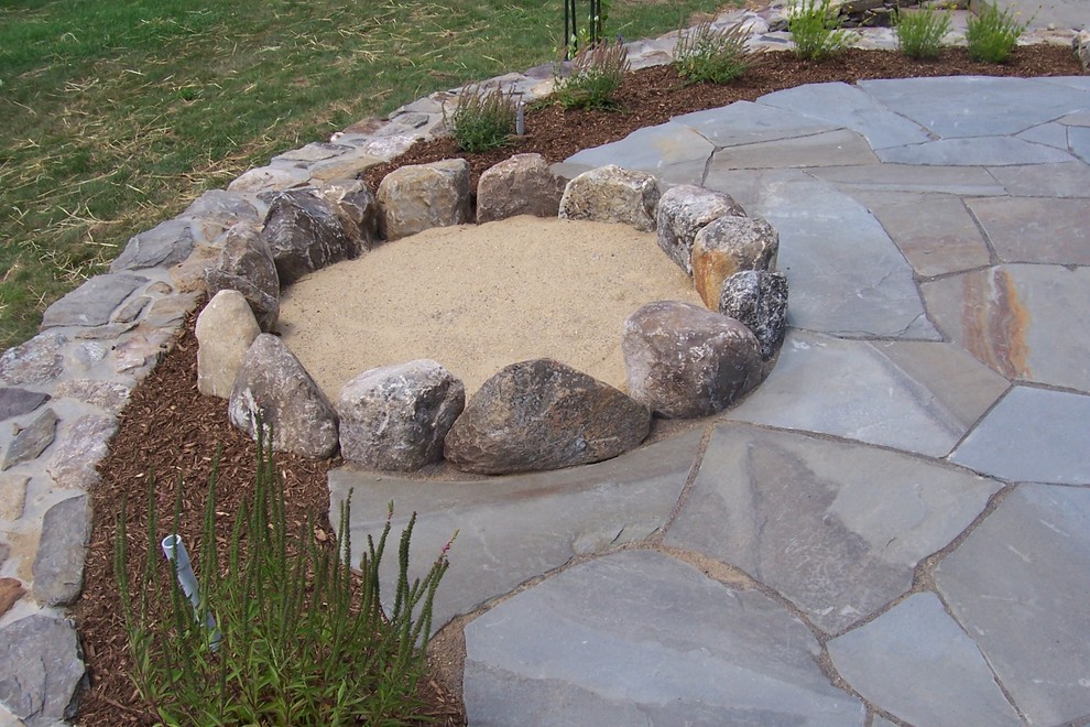 Large country backyard patio in Boston with a fire feature, natural stone pavers and no cover.