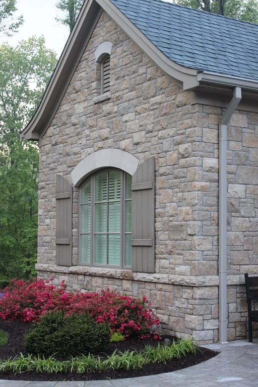 Photo of a traditional one-storey grey house exterior in Other with stone veneer and a shingle roof.